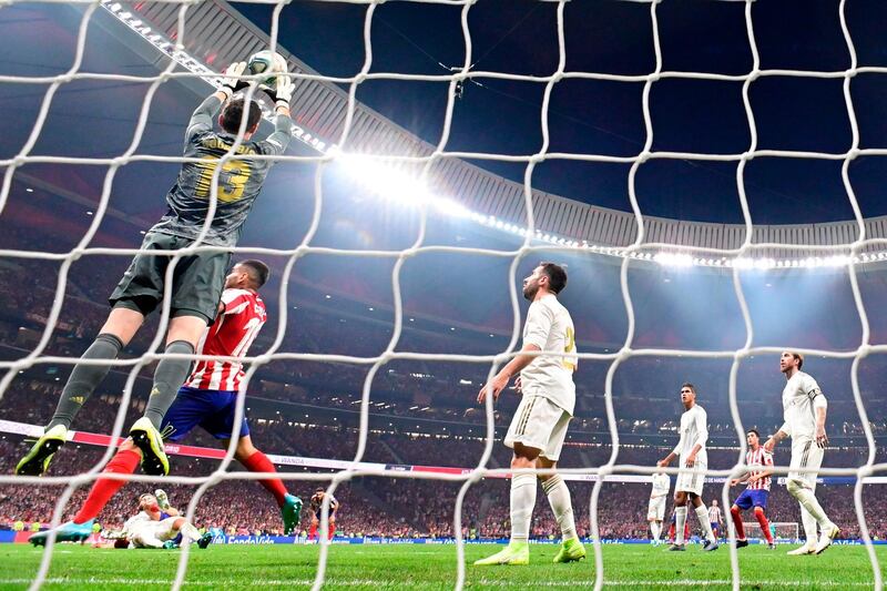 Atletico Madrid's Slovenian goalkeeper Jan Oblak (L) makes a save during the Spanish league football match between Club Atletico de Madrid and Real Madrid CF at the Wanda Metropolitano stadium in Madrid on September 28, 2019. / AFP / JAVIER SORIANO
