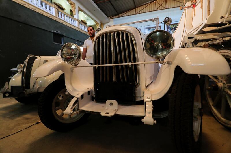 Ayman Sima stands next to an Italian 1928 Fiat 501 automobile at his father's store. Reuters