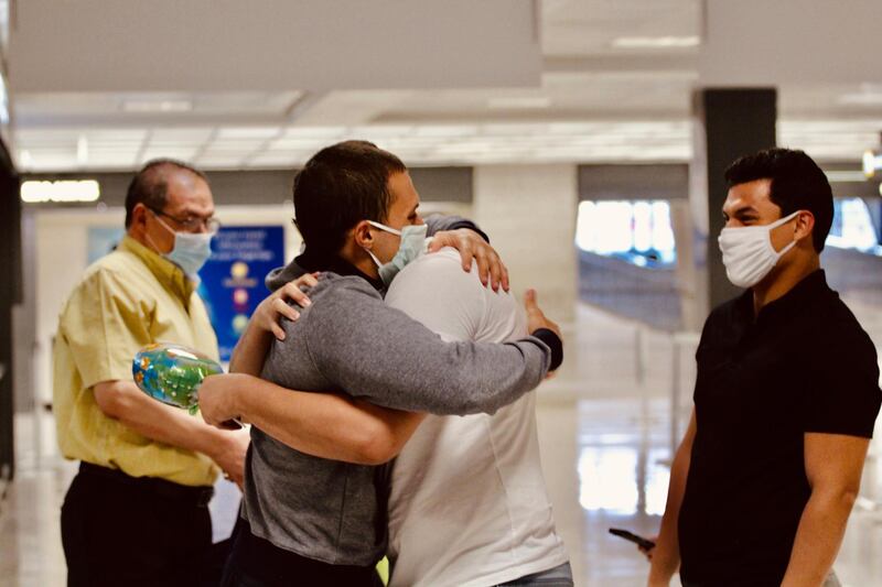 In this image provided by the Freedom Initiative, Mohamed Amashah, second from left, is greeted by family members upon arrival at Dulles International Airport in Dulles, Virginia. The American medical student detained without trial in an Egyptian prison for nearly 500 days.  AP