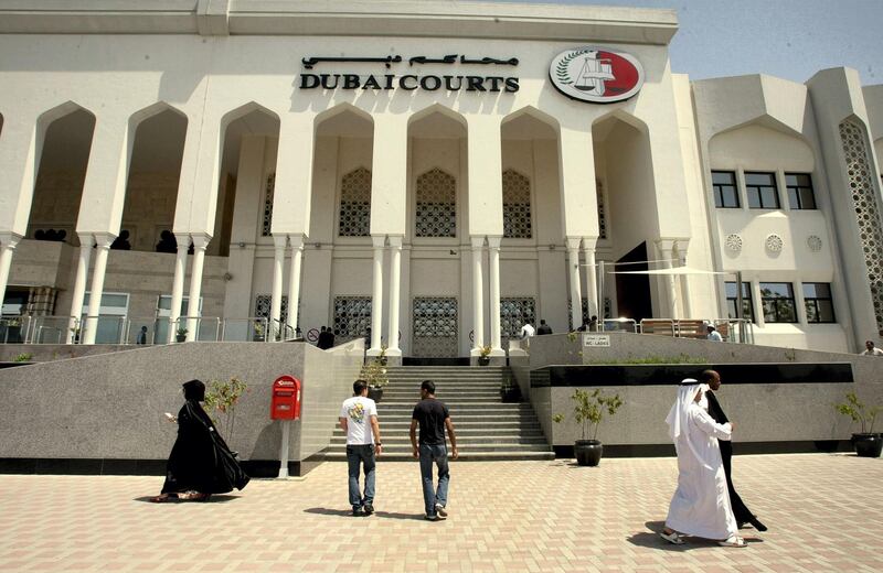 Pedestrians walk past Dubai's courts building during a hearing on April 04, 2010 in the case of a British couple sentenced to a month in jail after being convicted of kissing in public in a restaurant in the Muslim Gulf emirate. The couple's lawyer said the appeals court upheld the one-month prison sentence against the two, named by the British press as Ayman Najafi, 24, a British expat, and tourist Charlotte Lewis, 25. The couple were arrested in November 2009, after they were accused of consuming alcohol and kissing in a restaurant in the trendy Jumeirah Beach Residence neighbourhood.     AFP PHOTO/STR / AFP PHOTO