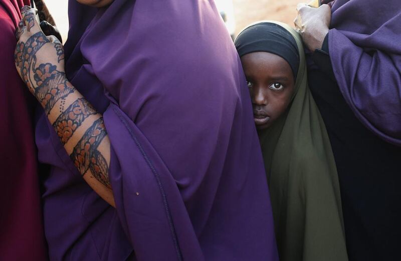 A girl stands in line in front of a bus with other passengers travelling to Nairobi, as they wait to be searched for weapons by Kenyan police, in the town of Mandera at the Kenya-Somalia border. Goran Tomasevic / Reuters
