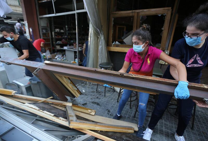 Volunteers clean the streets amid the wreckage. Reuters