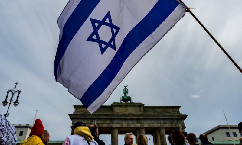 A demonstrator waves an Israeli flag during a rally in front of the Brandenburg Gate in Berlin. AFP