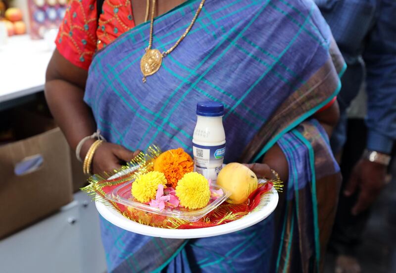 Dubai, United Arab Emirates - October 26, 2019: People bring plates with food and flowers to the Shiva Temple during Diwali in Bur Dubai. Saturday the 26th of October 2019. Bur Dubai, Dubai. Chris Whiteoak / The National