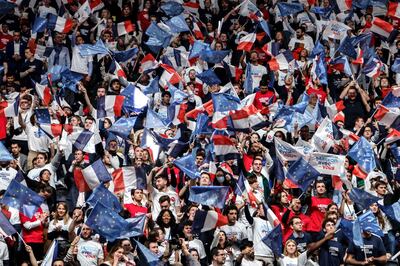 Mr Macron's supporters wave French and European flags before the rally at La Defense Arena in Paris. AFP 