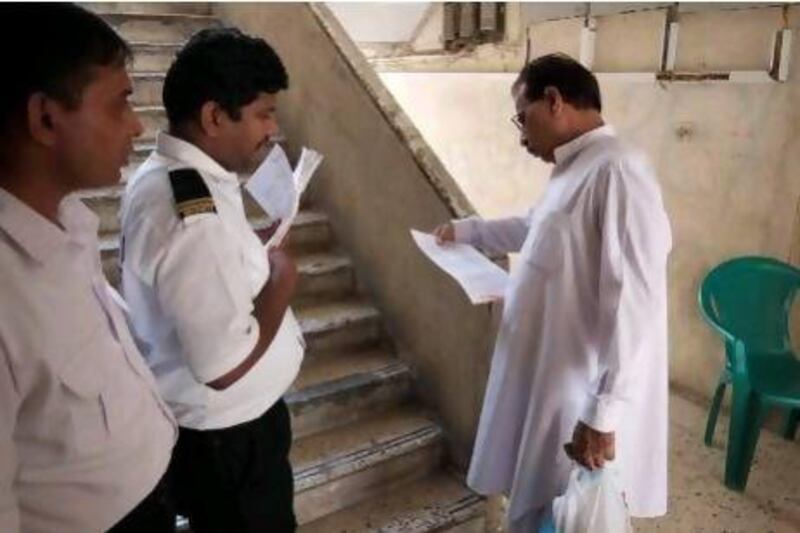 Security guards serve final eviction notices to tenants of Sheikh Rashid Colony.