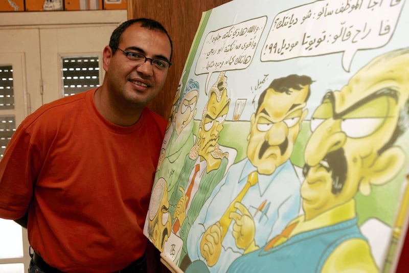 Jordanian cartoonist Emad Hajjaj poses for a photo at his office in Amman in March,2000. (Salah Malkawi for The National)