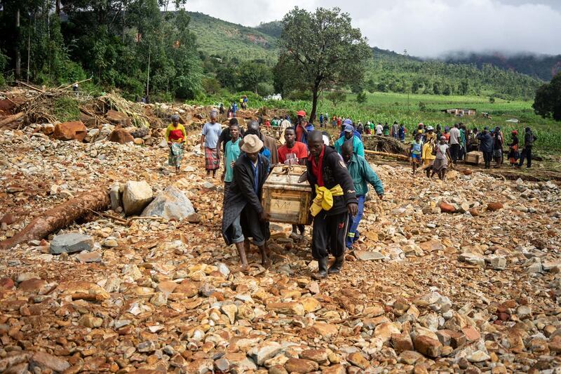 Men carry a coffin along a makeshift path on the river in Ngangu township Chimanimani, Manicaland Province, eastern Zimbabwe, after the area was hit by the cyclone Idai. AFP
