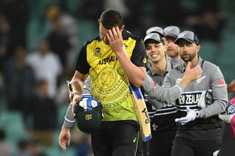 Australia's Josh Hazlewood leaves the field as New Zealand players celebrate their win. EPA