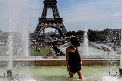 TOPSHOT - A woman cools off at the Trocadero Fountains near the Eiffel Tower in Paris, on July 22, 2019. Parisians were on July 22, 2019 bracing for potentially the hottest ever temperature in the French capital this week as a new heatwave blasted into northern Europe that could set records in several countries.  / AFP / ALAIN JOCARD

