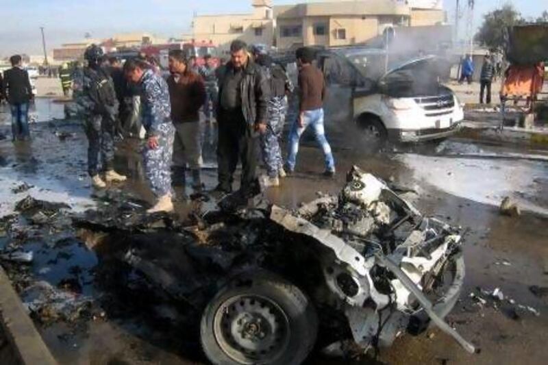 Iraqi policemen inspect the remains of a car used in a bomb attack in Kirkuk, north of Baghdad. Attacks across Iraq unfolded over a two-and-a-hour period which the interior ministry blames on Al Qaeda.