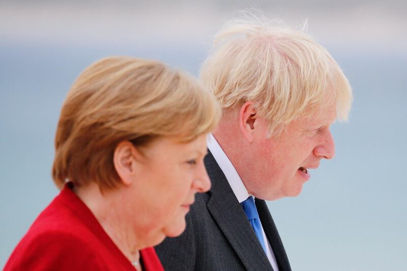 Britain's Prime Minister Boris Johnson and German Chancellor Angela Merkel look on as they arrive for the G7 summit. AFP