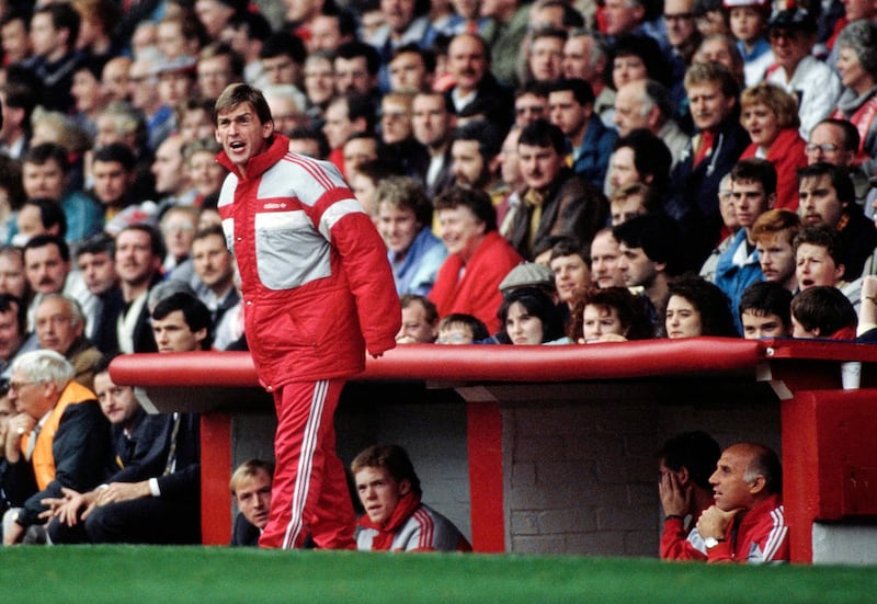 LIVERPOOL, ENGLAND - OCTOBER 22: Liverpool player manager Kenny Dalglish wearing a long Adidas jacket shouts from the touchline as Steve McMahon (l) and Steve Staunton look on from the bench during a First Division match against Coventry City on October 22, 1988 in Liverpool, United Kingdom. (Photo by Simon Bruty/Allsport/Getty Images/Hulton Archive)