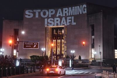 Protesters project a banner on the Brooklyn Public Library demanding an end to arms sales to Israel, near the home of Senator Chuck Schumer in New York, April 23, 2024. AP