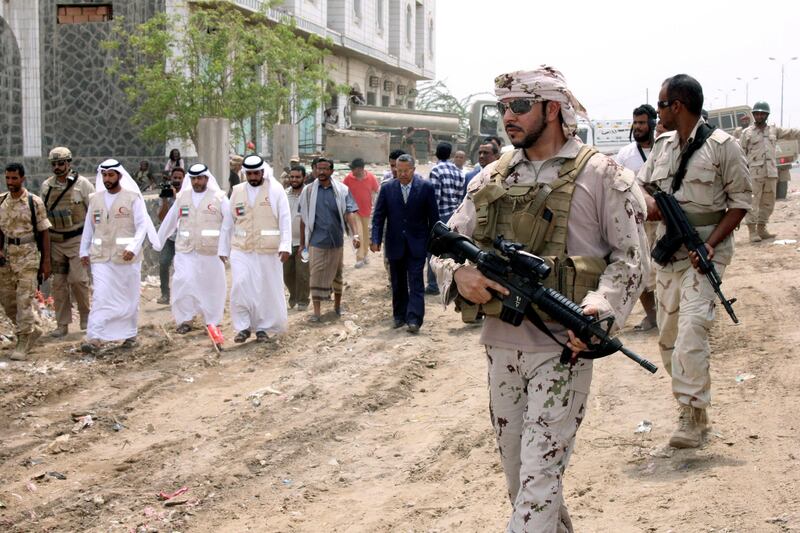 A UAE soldier walks as he escorts Yemen's Prime Minister Ahmed Obaid bin Daghar during a visit to the Red Sea port city of Mukha, Yemen August 6, 2017. REUTERS/Fawaz Salman