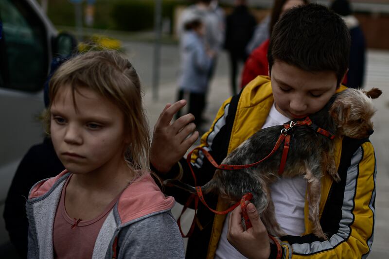 Ukrainians Oria Oscaria and her brother Ego with their pet dog after arriving in Cizur Menor, northern Spain. AP