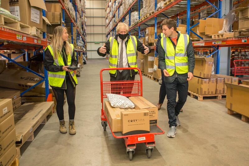 Boris Johnson walks through the warehouse of Next World Sports. AP Photo