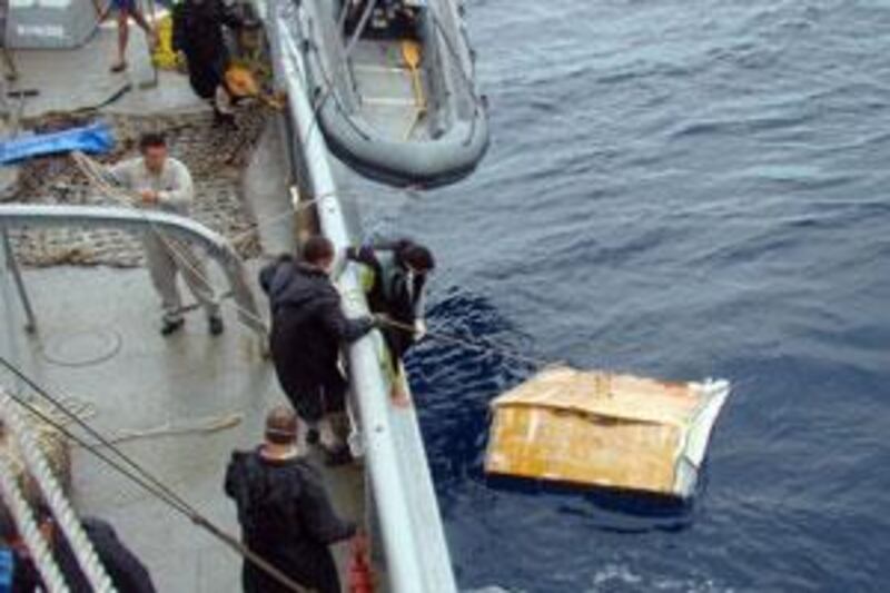 Members of a Brazilian Navy ship pick up a piece of debris of the Air France Flight 447 from the Atlantic ocean.