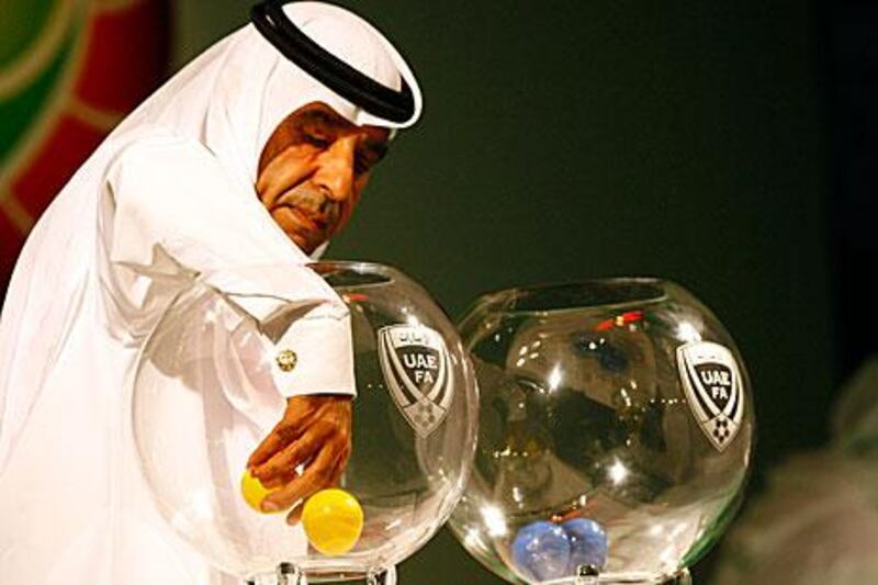 Rashed Amiri, of the Dubai Sports channel, draws balls to determine the groups for the 2011/12 Etisalat Cup yesterday.