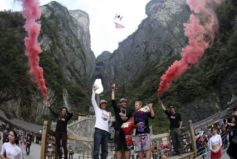 Noah Banson of the US, centre, shown as the winner of the wingsuit flying tournament at China's Tianmen Mountain on Sunday. China Daily / Reuters