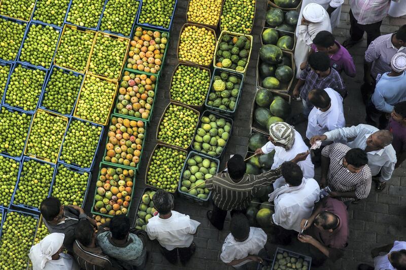 Ahmed, Oman: Ahmed showcases Al Buraimi’s seasonal fruits and vegetable market in this colourful shot as the seller auctions his produce to incoming buyers.