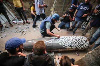 Belal Khaled painting a calligraphy of Samih Al-Qasim's resistance poem on a missile that fell on Gaza. Belal Khaled