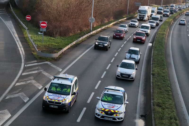 Police cars drive ahead of a convoy heading to Paris, in Lille, northern France. AP Photo