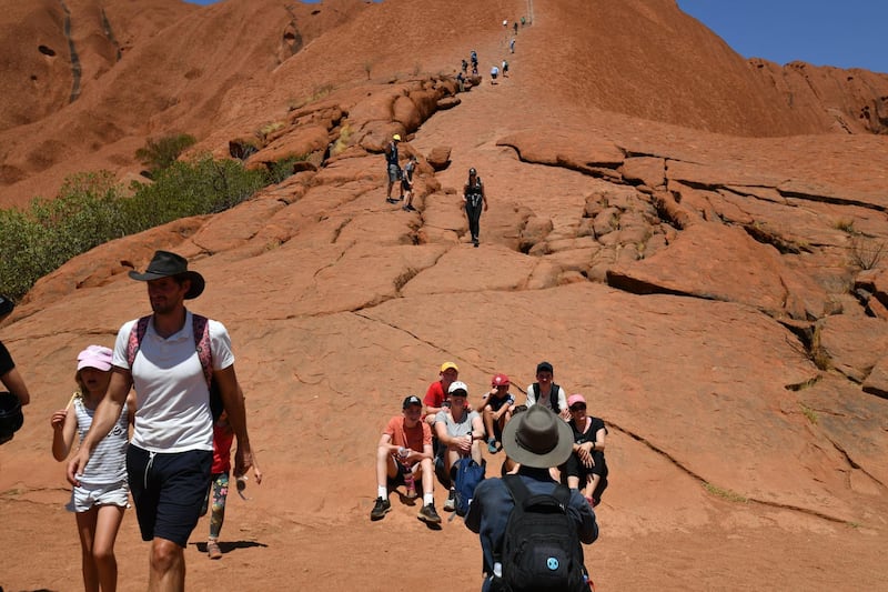 Tourists climb the Uluru, also known as Ayers Rock. AFP