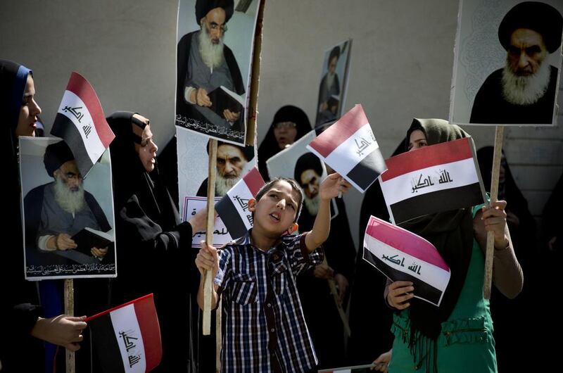 An Iraqi boy holds a picture of Iraq’s most senior Shiite cleric, Grand Ayatollah Ali Al Sistani as he attends a demonstration against the Islamic State – formerly known as the ISI – on the streets of Tehran on June 20, 2014. Maryam Rahmanian for The National