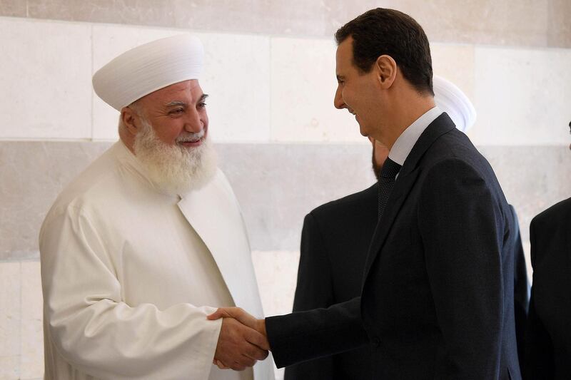 President Bashar Al Assad greets Adnan Al Afyouni, the mufti of Damascus, at the inauguration of the International Sham Islamic Centre in the Syrian capital on May 20, 2019. Sana / AFP