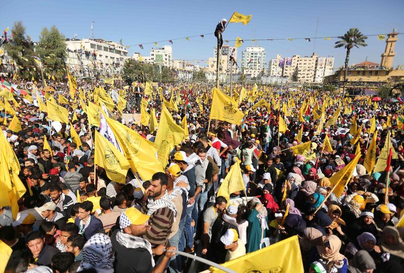 Fatah supporters wave the party flag as they take part in a rally in Gaza City on November 11, 2017. marking the death anniversary of late Palestinian leader Yasser Arafat.
The anniversary event was billed as a show of national unity after the Islamists of Hamas struck a reconciliation agreement last month with the rival Fatah movement founded and led by Arafat until his death in 2004. / AFP PHOTO / MAHMUD HAMS