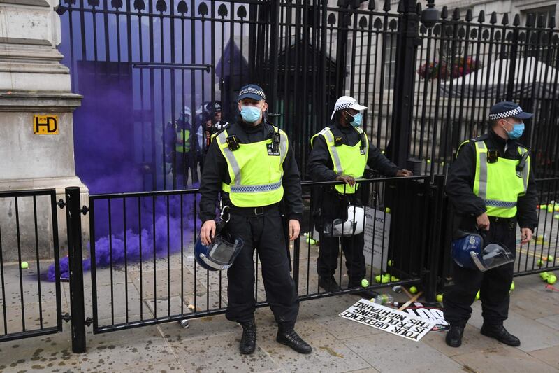 A smoke canister goes off during an anti-Vaccine and anti-lockdown demonstration outside Downing street in central London, on June 26, 2021.  / AFP / DANIEL LEAL-OLIVAS
