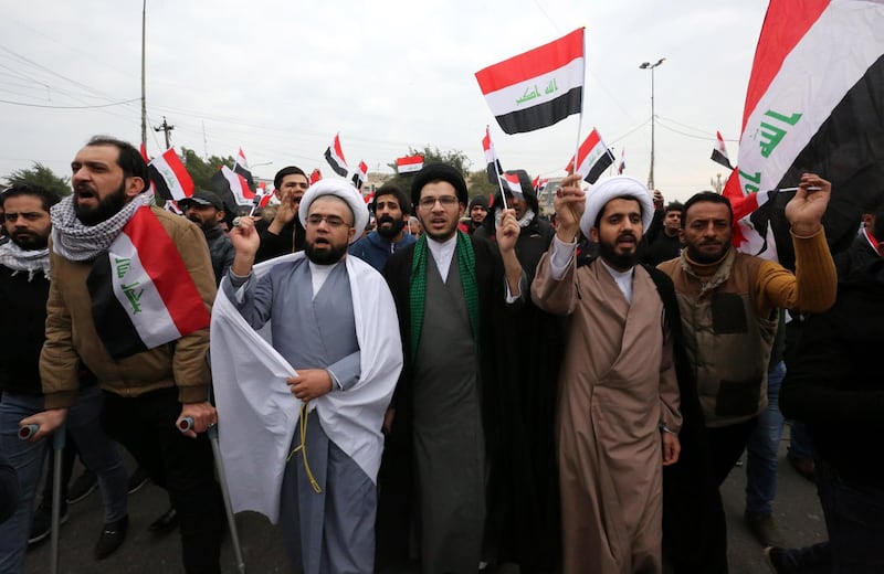Supporters of Moqtada Al Sadr chant slogans and carry the Iraqi national flag during a demonstration. EPA