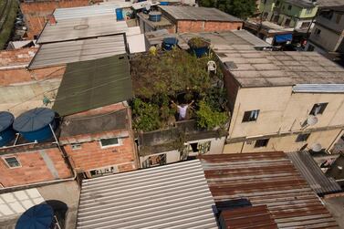 In this Jan.10, 2020 photo, Luis Cassiano shows his green roof at his home in Arara Park favela, Rio de Janeiro, Brazil. "I think people will, one day, really wind up joining. We'll need it. Just look at the heat of all those roofs together!" (AP Photo/Renato Spyrro)