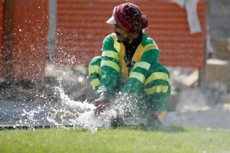 A man cools down with water while working in the heat at a construction site in Abu Dhabi. Rich-Joseph Facun/The National