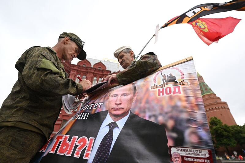 Pro-Kremlin activists hold a portrait of President Vladimir Putin near Red Square on Saturday. AFP