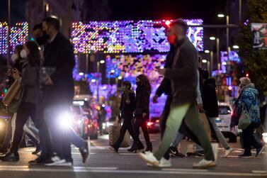People walk past Christmas lights in Spain. Getty Images