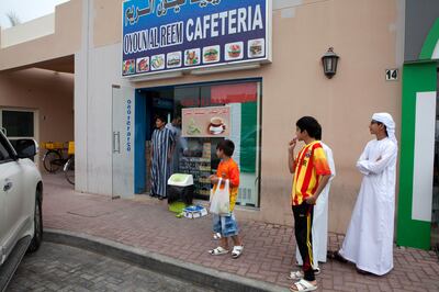 Dubai, United Arab Emirates, Nov 21, 2013 -   Kids outside Oyoun al Reem shop in Za'abeel area famous for cooking Chilies zaabeel sandwich and Chips Oman sandwich. ( Jaime Puebla / The National Newspaper ) National *** Local Caption ***  JP1121-Sandwich11.jpg