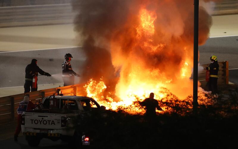 Fire marshalls try to put out the fire after  Romain Grosjean's crash. Getty