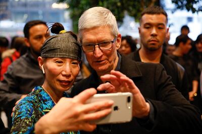 Tim Cook, Chief Executive Officer of Apple Inc., takes a selfie with a customer and her iPhone as he visits the Apple Store in Chicago, Illinois, U.S., March 27, 2018.   REUTERS/John Gress