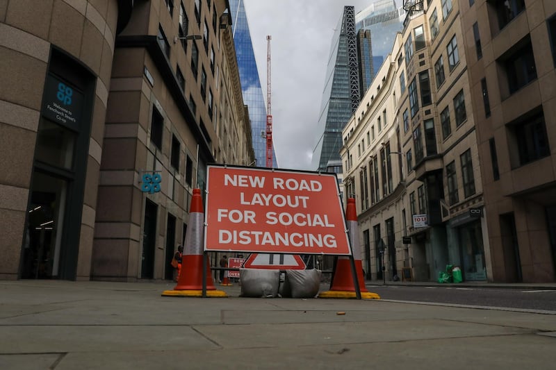 A sign reading "New road layout for social distancing" stands in the Square Mile financial district in London. Bloomberg