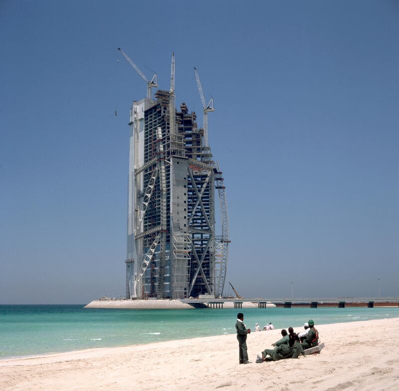 ca. 1980-1997, Dubai, United Arab Emirates --- Indian workmen relax in front of the Chicago Beach Hotel tower, the tallest building in the United Arab Emirates. --- Image by Â© James Davis/Eye Ubiquitous/Corbis

FOR FRIDAY NOV 30, 2013 NATIONAL DAY STORY IN BIZ *** Local Caption ***  bz29no-ND-Hotels-03.jpg