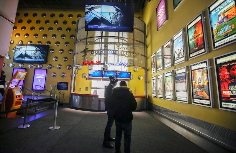 People look at the movie choices available at a cinema as Quebec allows the reopening of movie theatres but not the selling of food and drinks, which includes popcorn, during the outbreak of the coronavirus disease in Montreal, Canada. Reuters