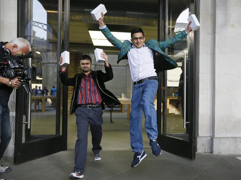 The first people in the queue, Sam Sheikh, left, and Jameel Ahmed, right, celebrate for the media after buying the new iPhone6, outside the Apple shop in London. Kirsty Wigglesworth / AP Photo