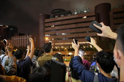 Protesters flash their smartphones lights as they gather near the Polytechnic University to urge authorities to release the remaining trapped protesters, in Hong Kong, Monday, Nov. 25, 2019.  Hong Kong's pro-democracy opposition won a stunning landslide victory in weekend local elections in a clear rebuke to city leader Carrie Lam over her handling of violent protests that have divided the semi-autonomous Chinese territory. (AP Photo/Kin Cheung)