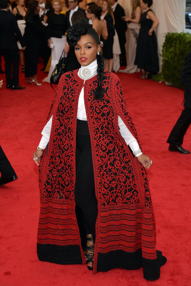 Janelle Monae, wearing a red and black embroidered Tadashi Shoji tulle cape, arrives at the 2014 Met Gala on May 5, 2014. EPA