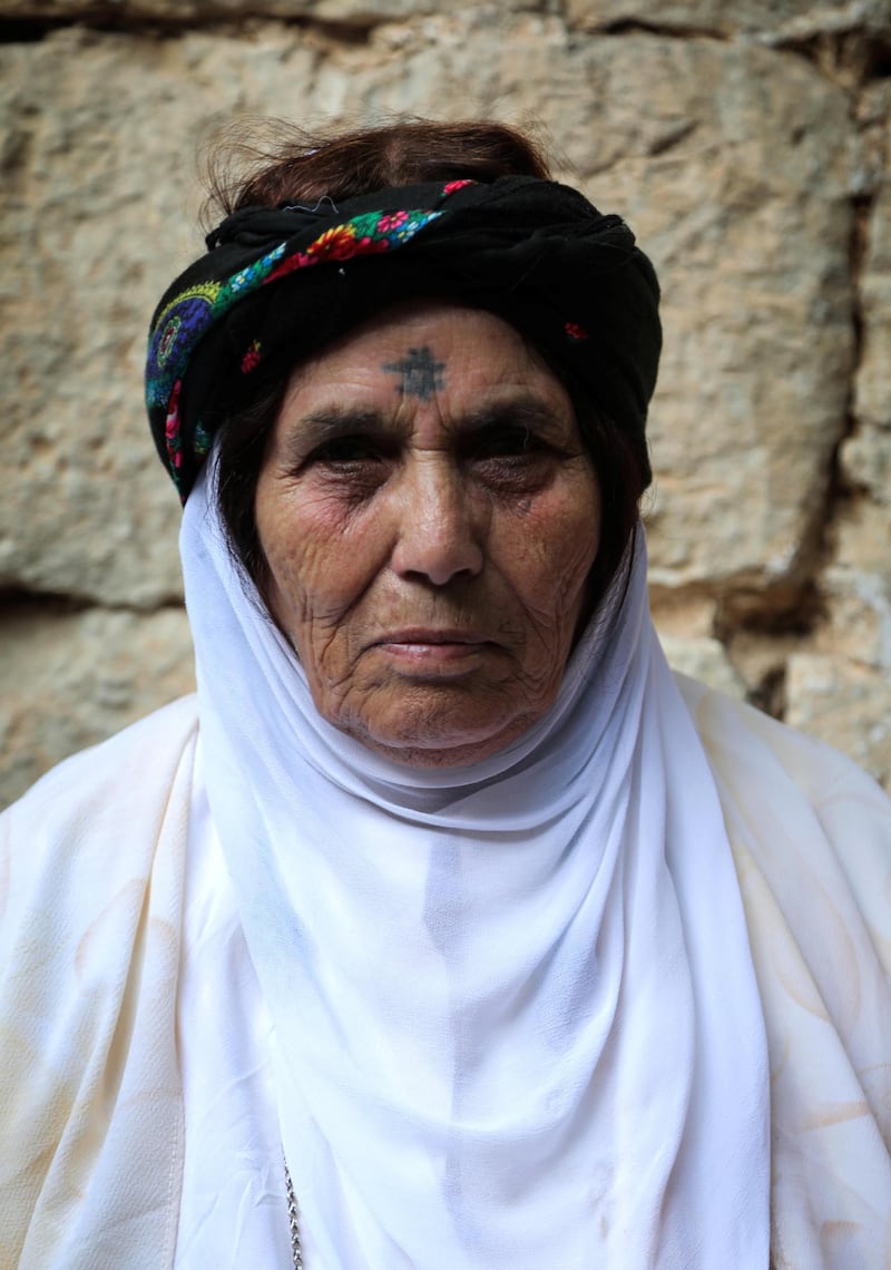 An Iraqi Yazidi woman visits the Temple of Lalish, in a valley near the Kurdish city of Dohuk, about 430km northwest of the Iraqi capital Baghdad, on October 9, 2019. - Of the 550,000 Yazidis in Iraq before the Islamic State (IS) group invaded their region in 2014, around 100,000 have emigrated abroad and 360,000 remain internally displaced. (Photo by SAFIN HAMED / AFP)