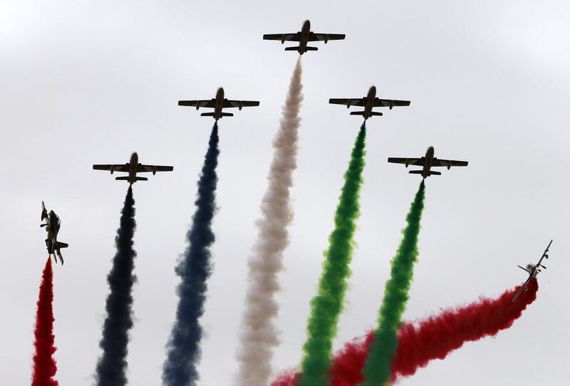 Aircraft leave a coloured smoke trail during the military show launching Idex 2015. AFP

