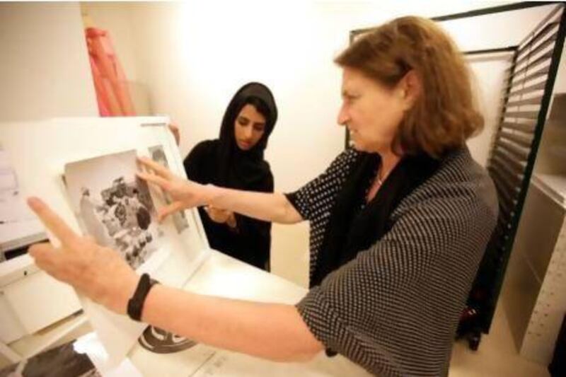 Salma al Mari, left, a student at Zayed Univerisity and Susan Mesieles put the finishing touches to a new exhibition about the Emirati family put on by students at Zayed University in Abu Dhabi . Sammy Dallal / The National