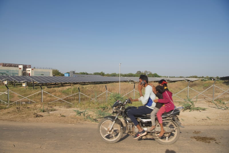 The solar power plant in Sujanpur, near Modhera, is seen in the background